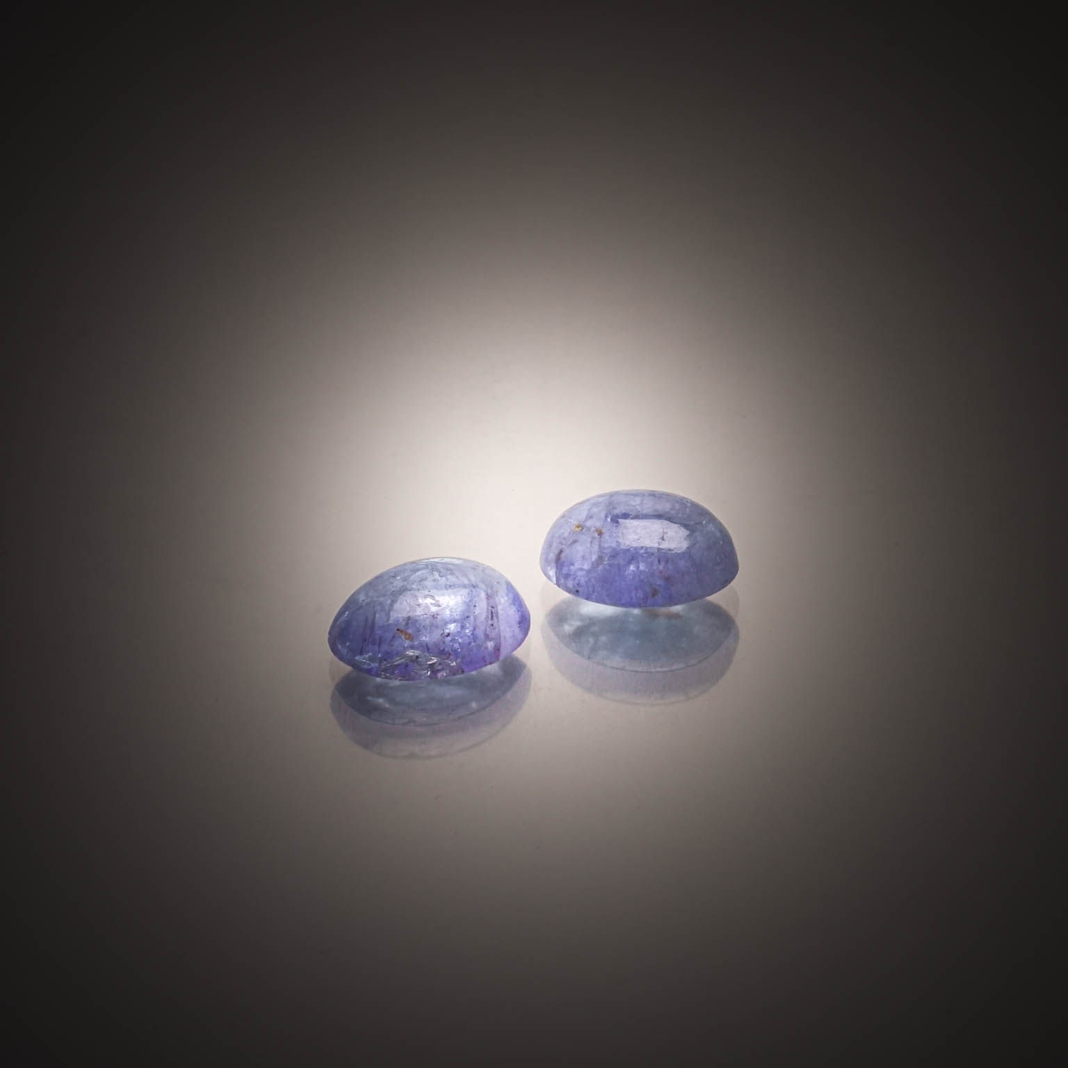 Lot de deux tanzanites ovales cabochons sur papier. - Lazuli
