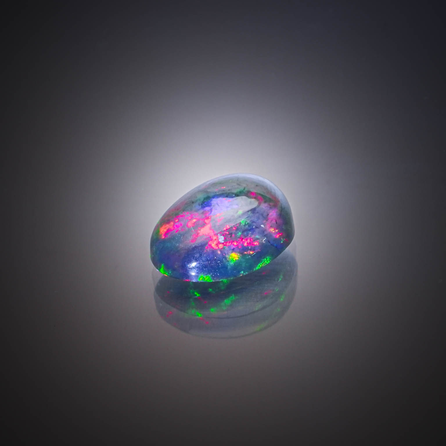 Opale noire ovale cabochon sur papier. - Lazuli