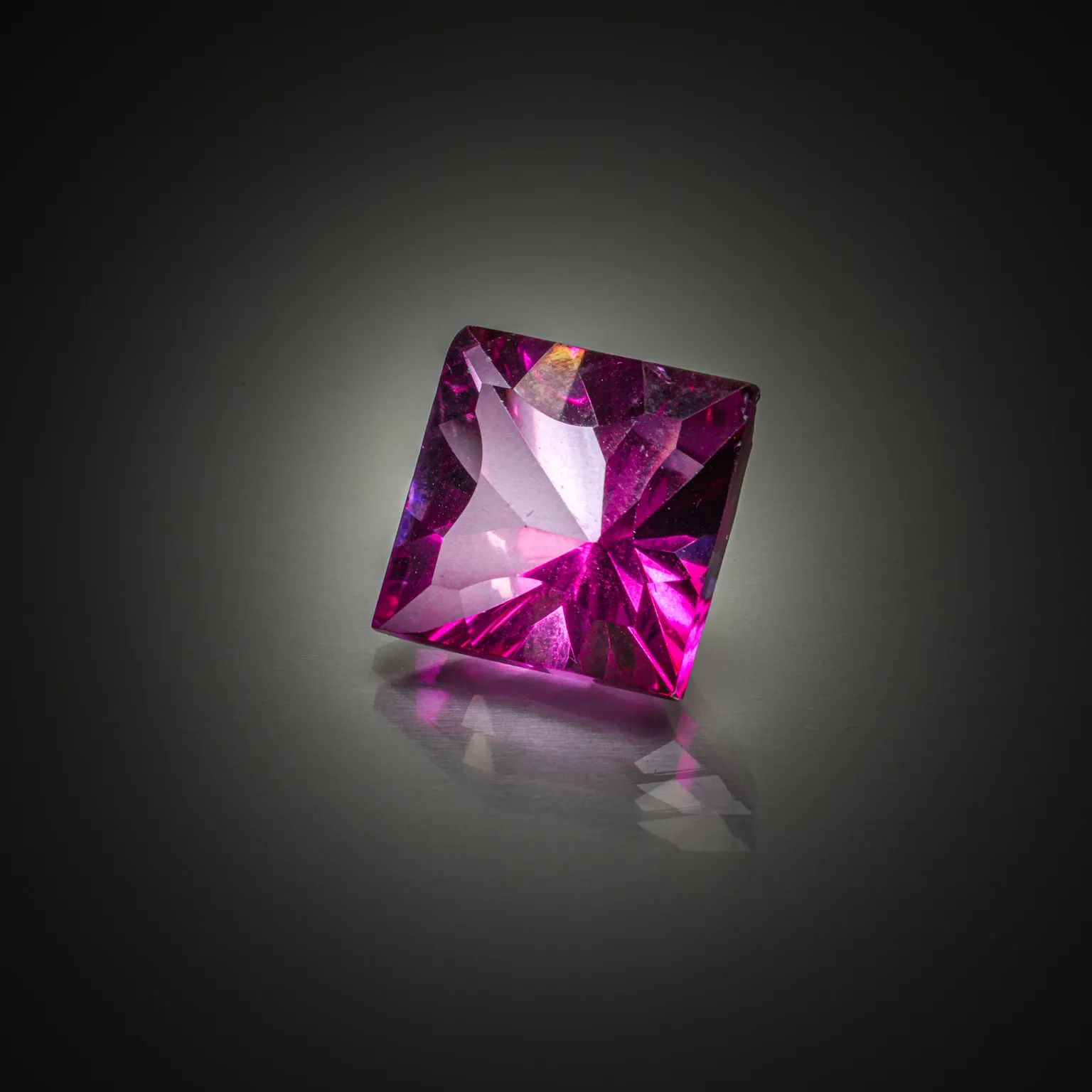 Lot de trois tourmalines paraïbas brutes et une tanzanite brute sur papier. - Lazuli
