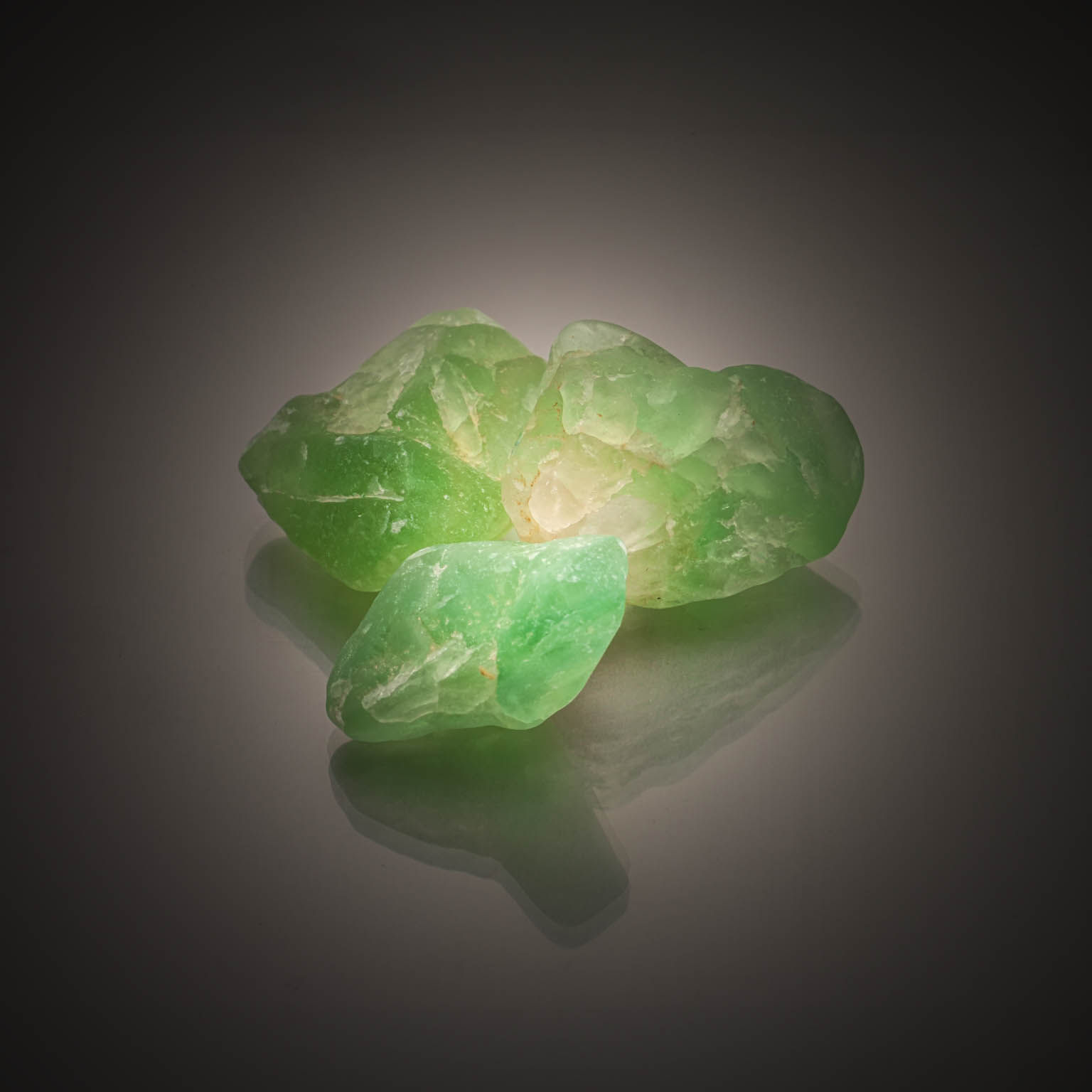 Lot de trois fluorites vertes brutes sur papier. - Lazuli