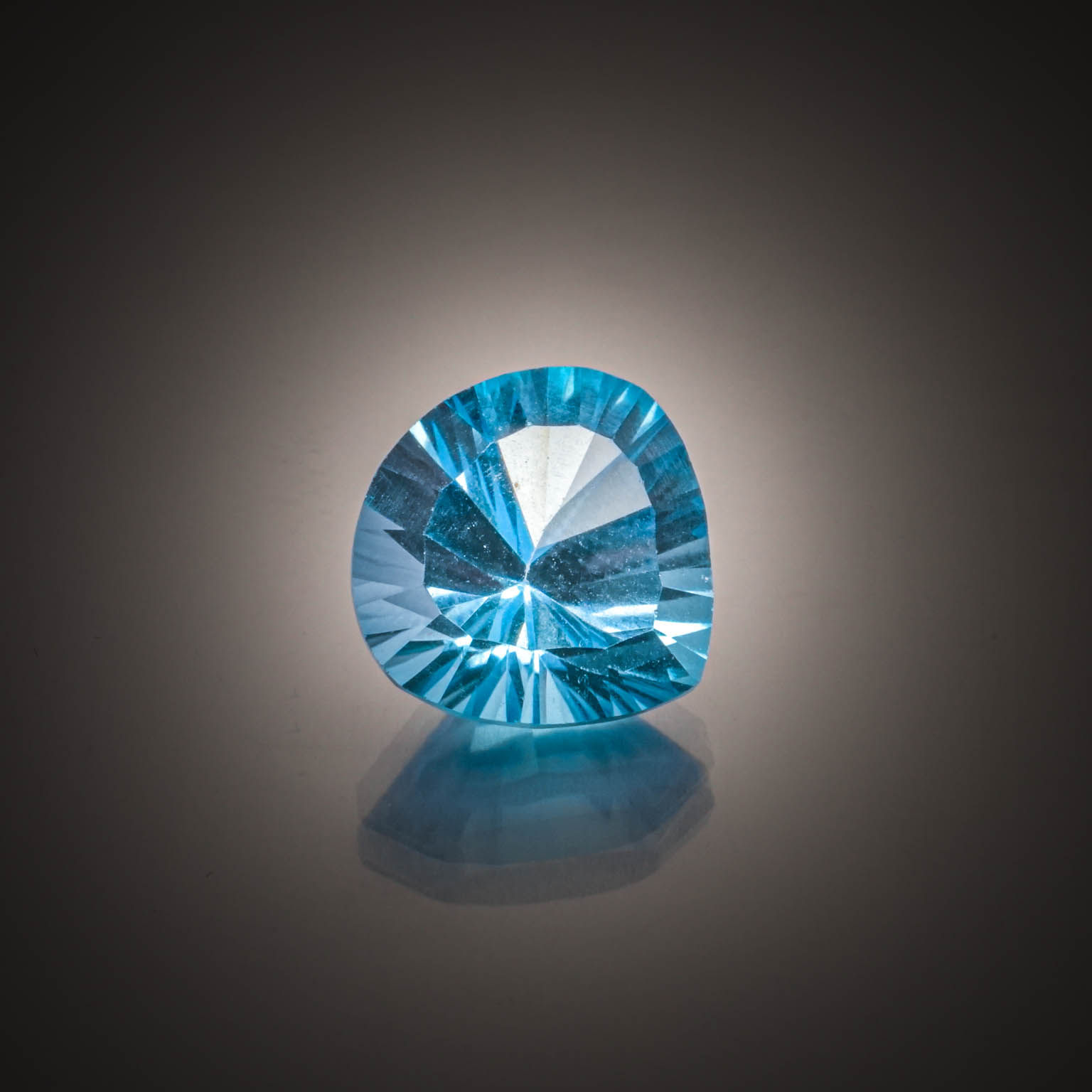 Topaze bleue (Swiss Blue) poire concave sur papier. - Lazuli