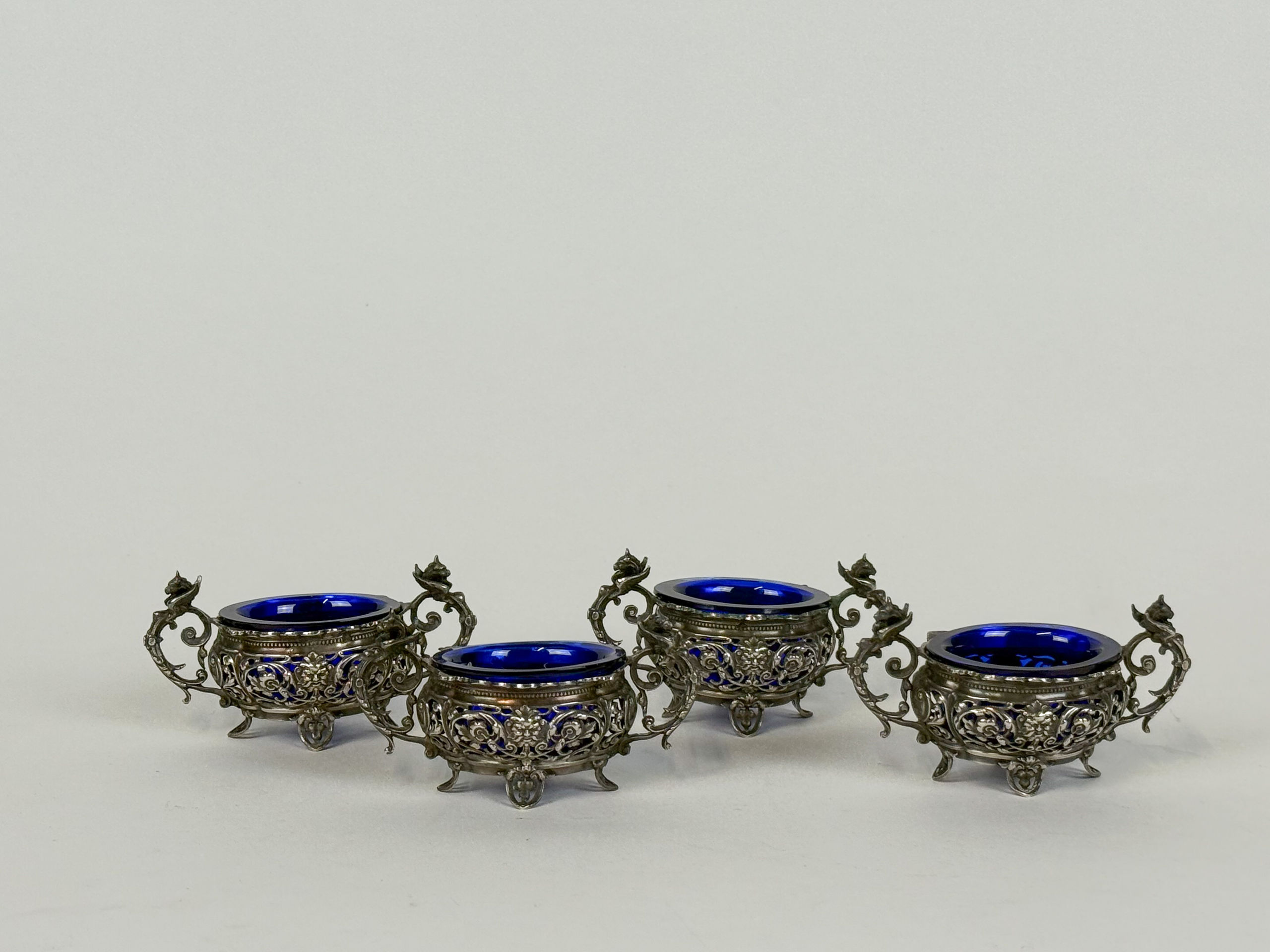 Paire de bougeoirs en bronze à patine noir et dorée, le fût cannelé reposant sur un piètement tripode stylisant des feuilles d&rsquo;acanthe. - Lazuli