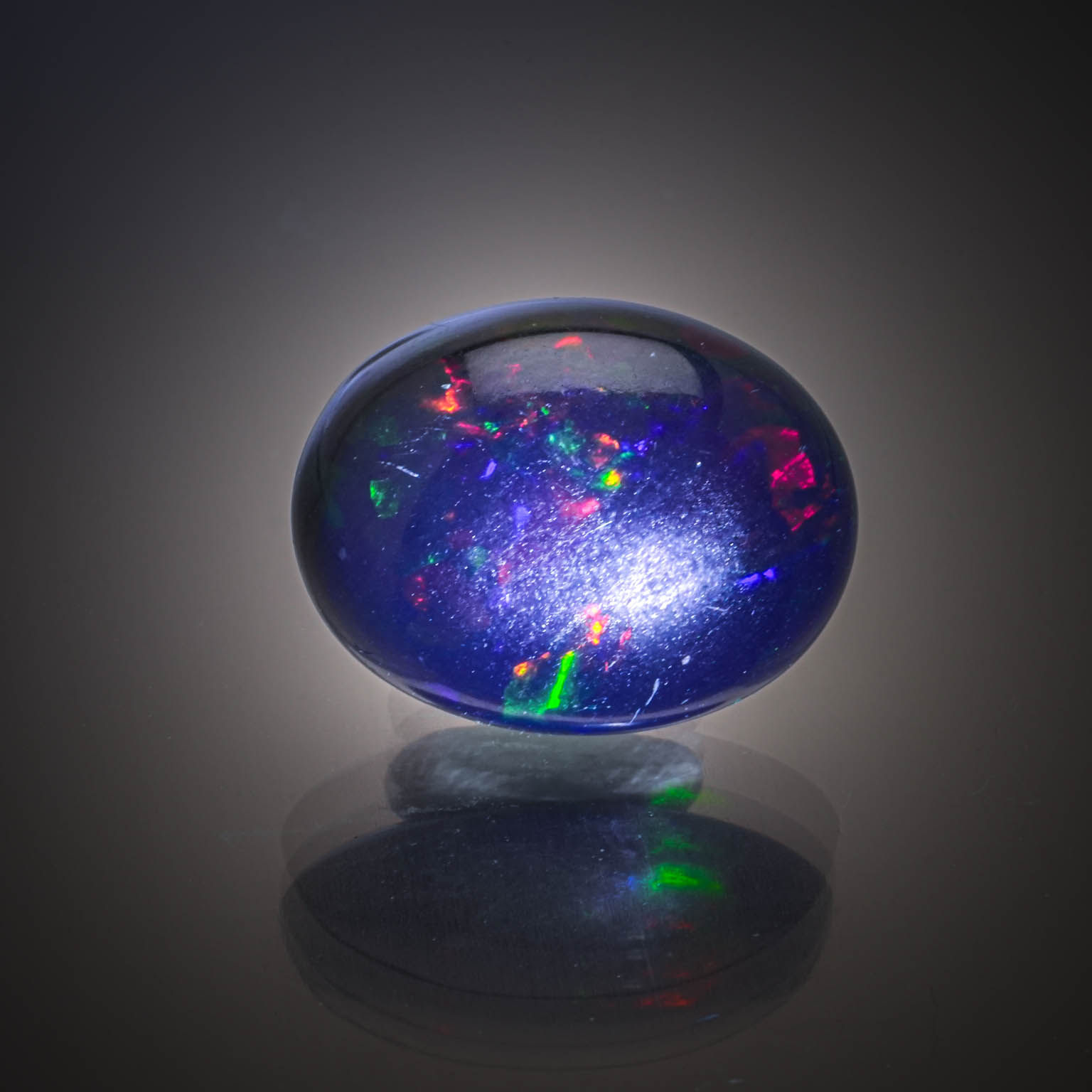 Opale ovale cabochon sur papier. - Lazuli