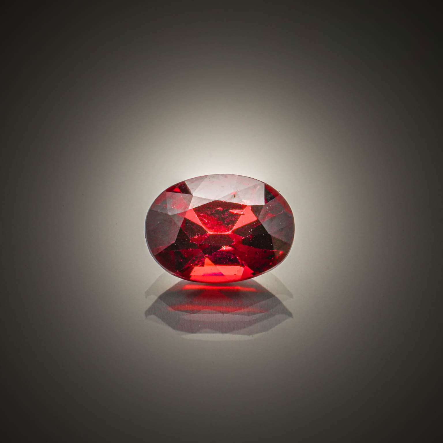 Grenat rhodolite violet/rouge ovale sur papier. - Lazuli