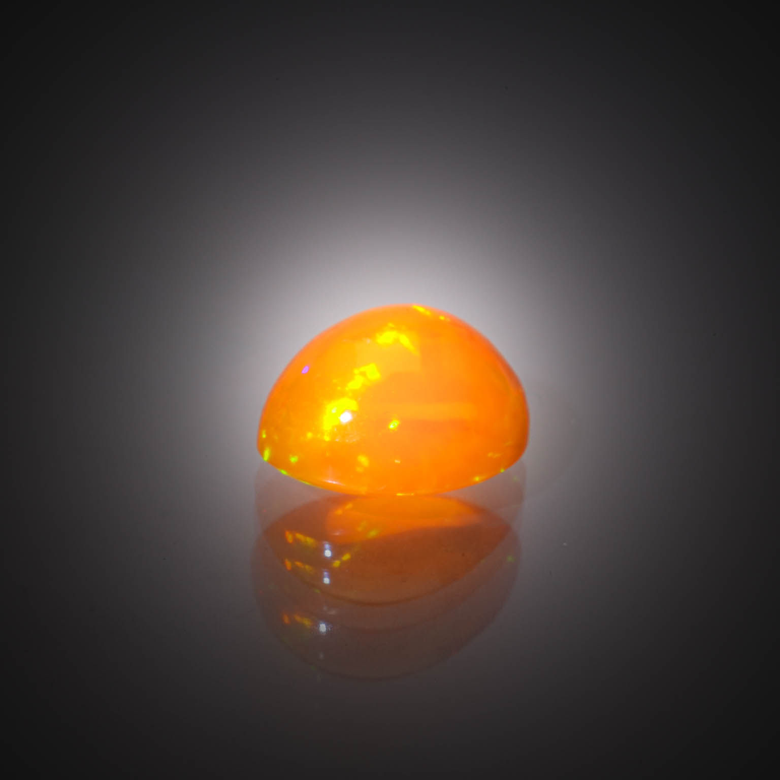Opale orange ovale cabochon sur papier. - Lazuli
