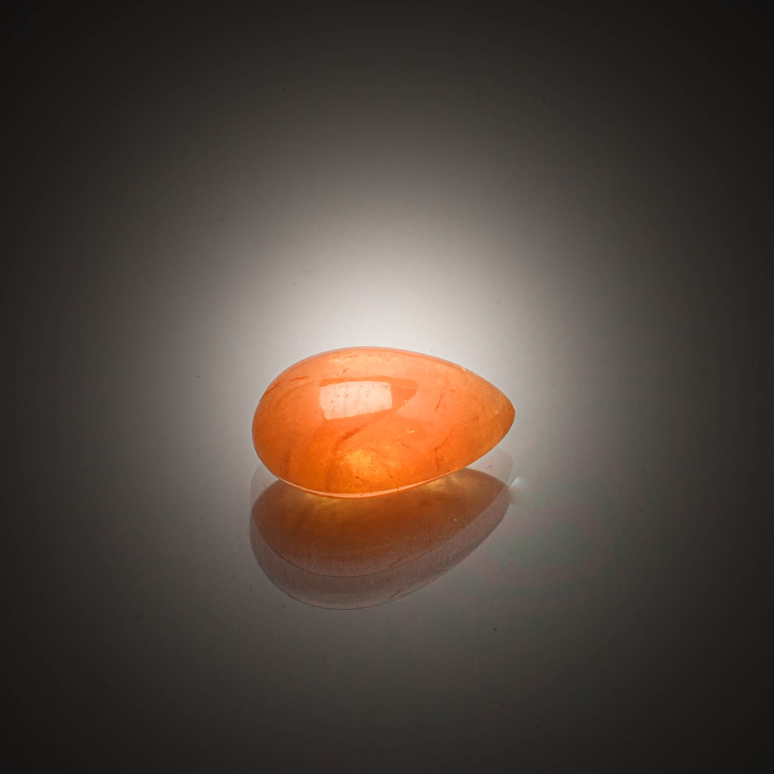 Grenat spessartite orange poire cabochon sur papier. - Lazuli