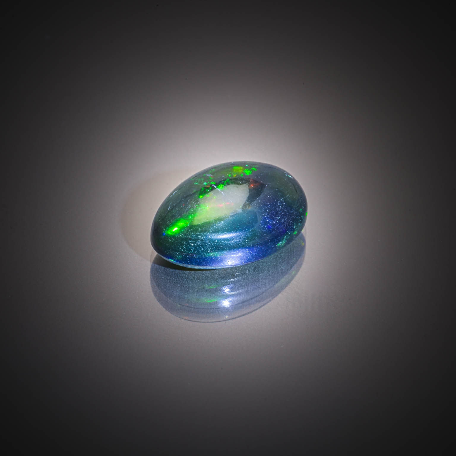 Opale noire ovale cabochon sur papier. - Lazuli