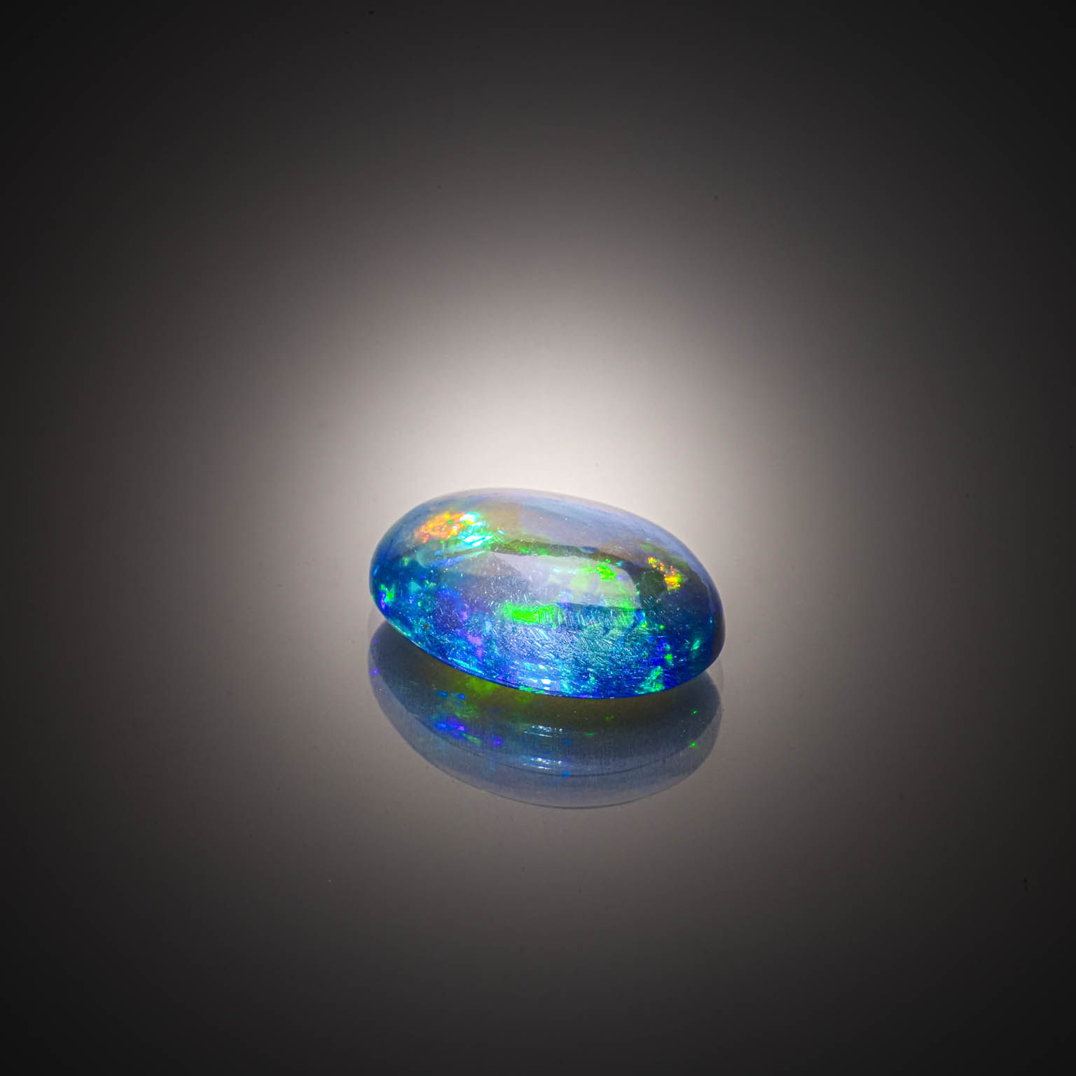Opale noire ovale cabochon sur papier. - Lazuli