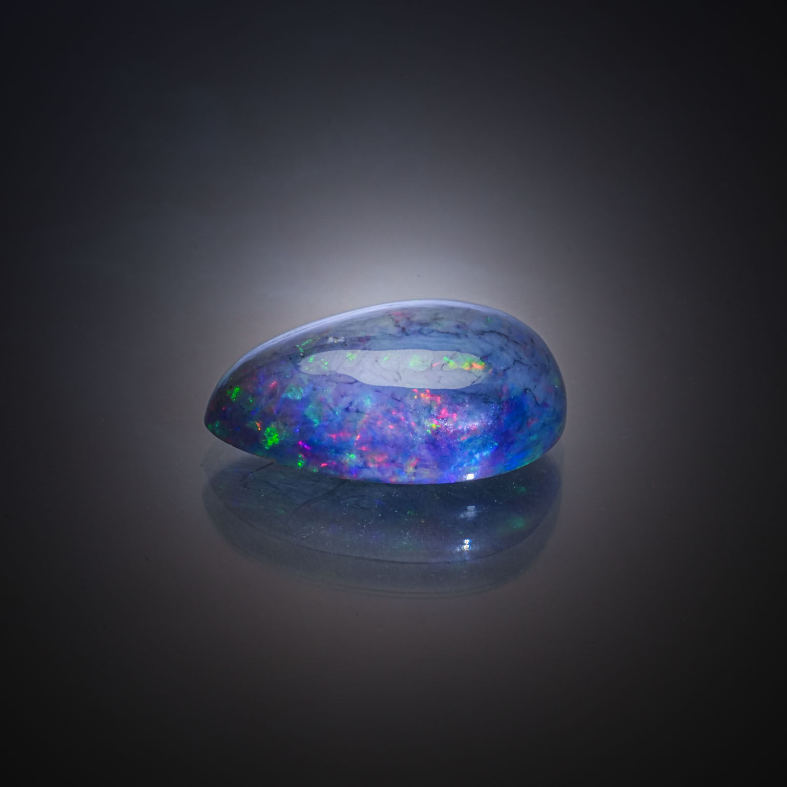 Opale ovale cabochon sur papier. - Lazuli