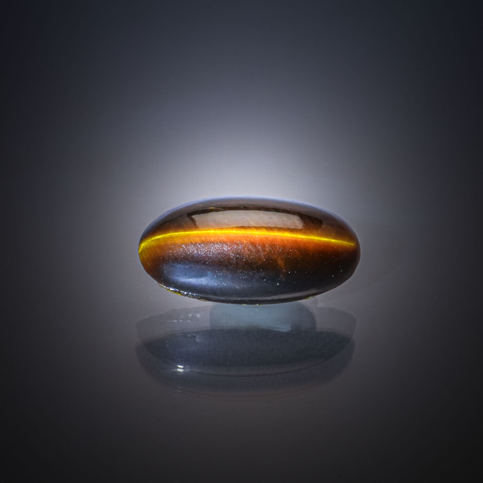 Quartz œil de tigre ovale cabochon sur papier. - Lazuli