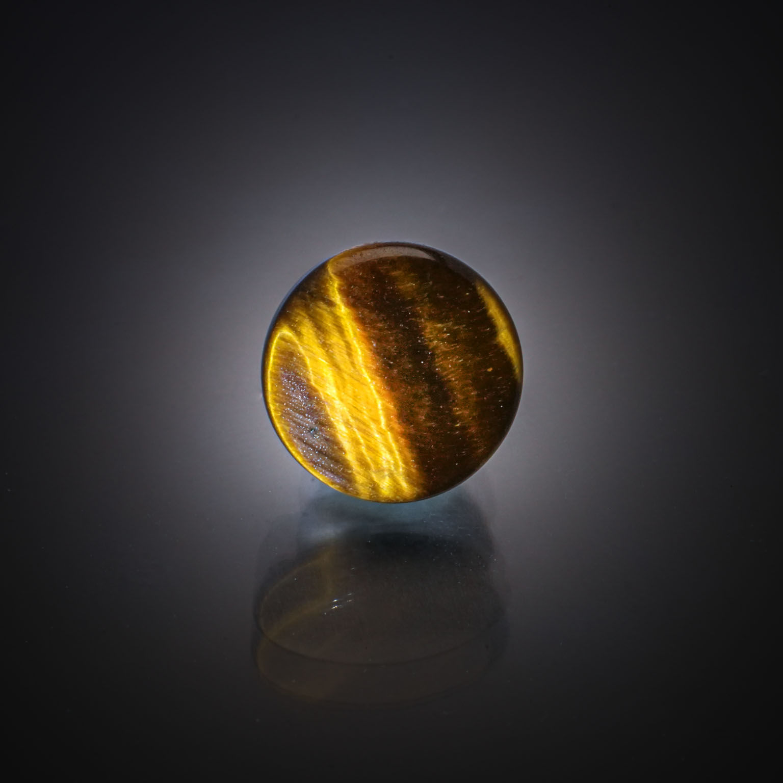 Quartz œil de tigre rond cabochon sur papier. - Lazuli