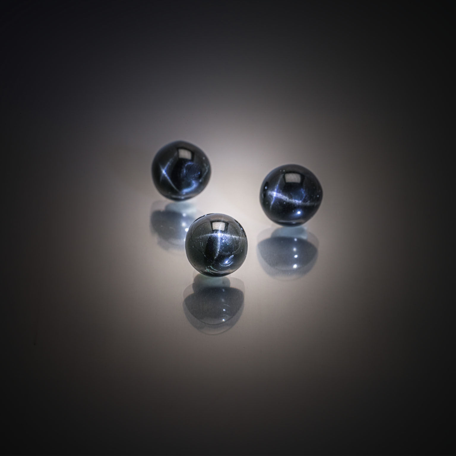 Lot de trois diopsides noirs étoilés (4 branches) ronds cabochons sur papier. - Lazuli