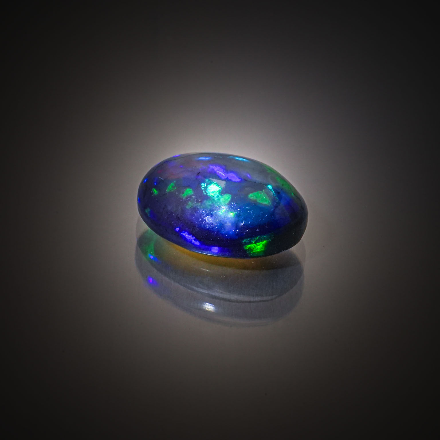 Opale noire poire cabochon sur papier. - Lazuli