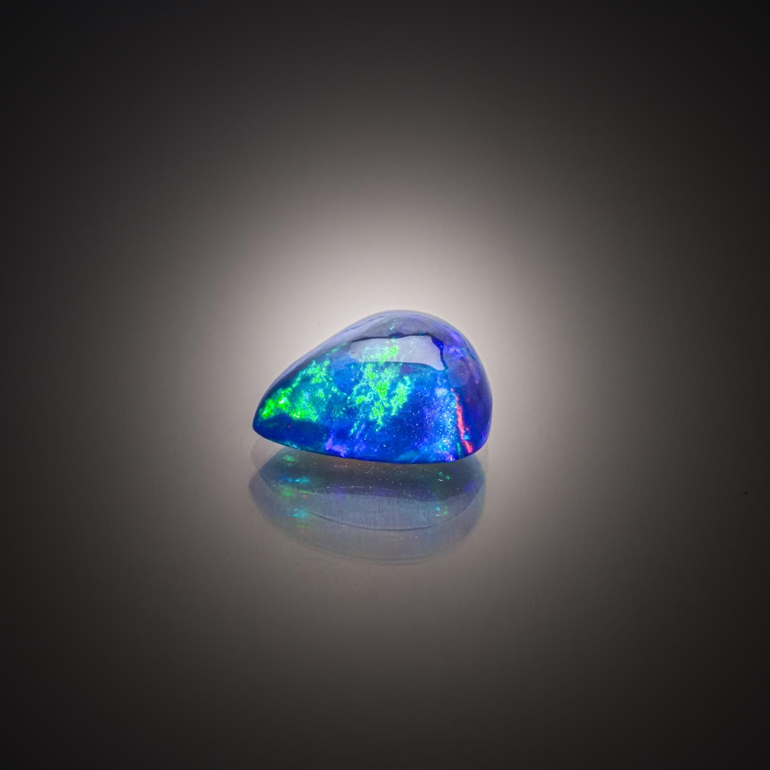 Opale noire poire cabochon sur papier. - Lazuli