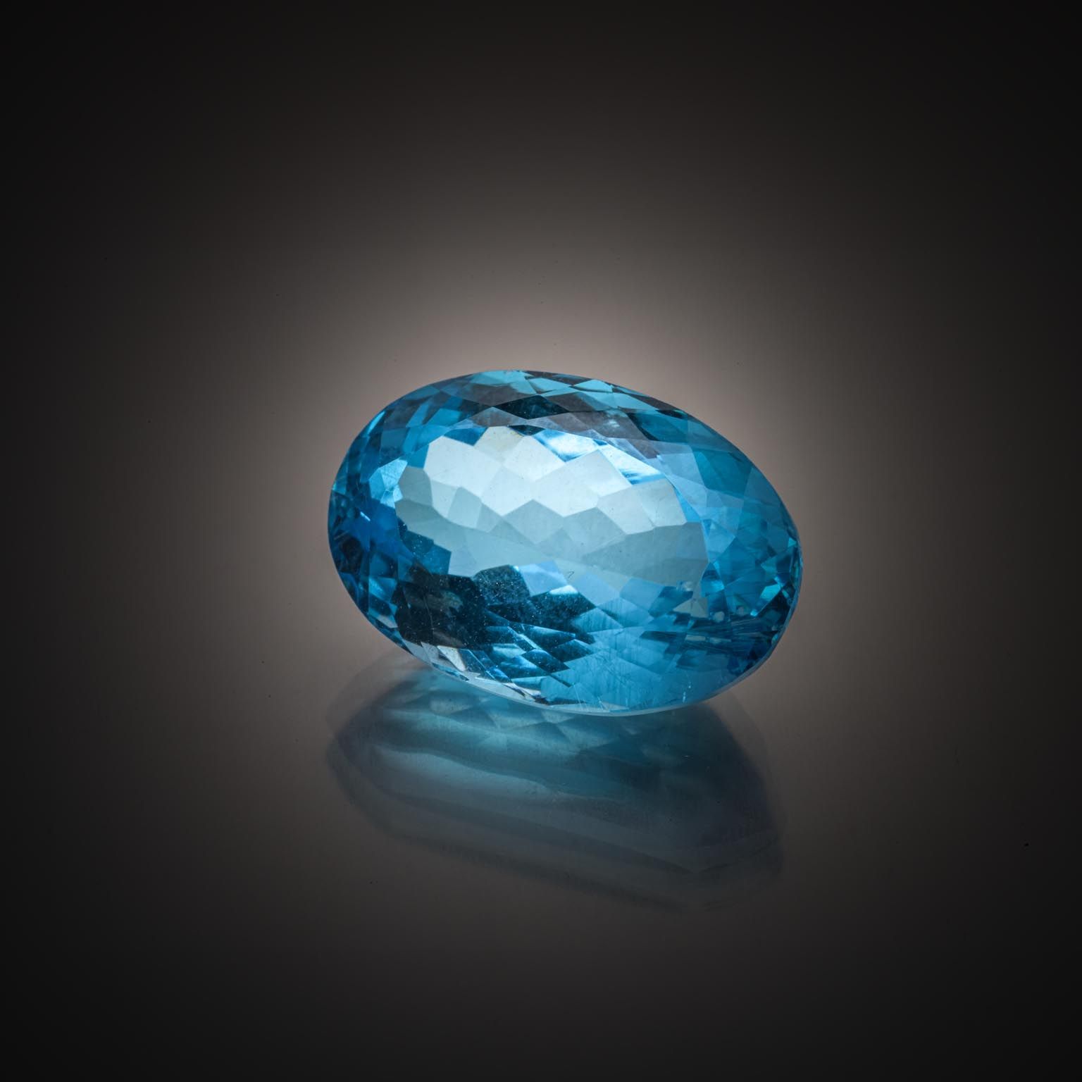 Topaze bleue (Swiss Blue) ovale sur papier. - Lazuli