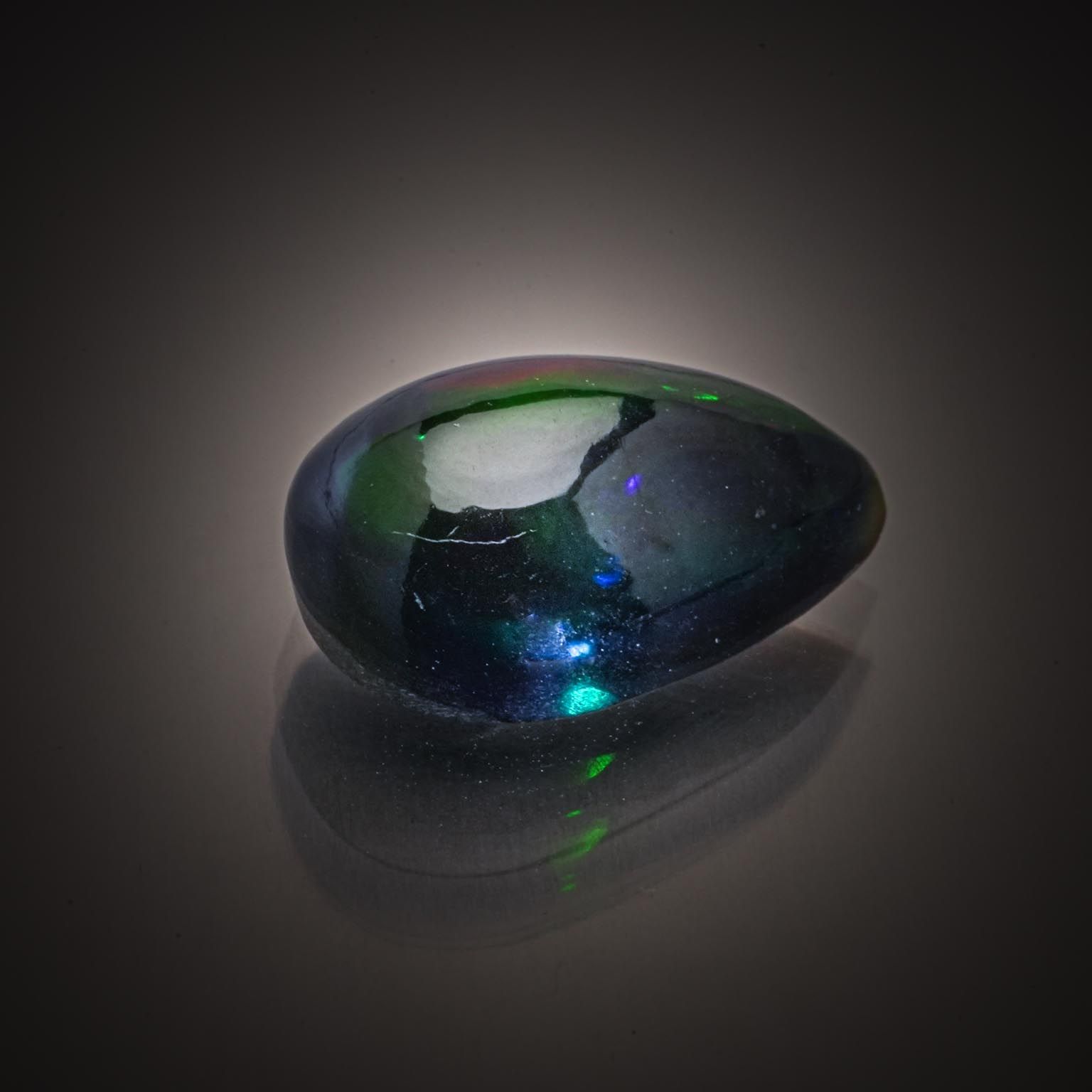 Opale boulder ovale cabochon sur papier. - Lazuli