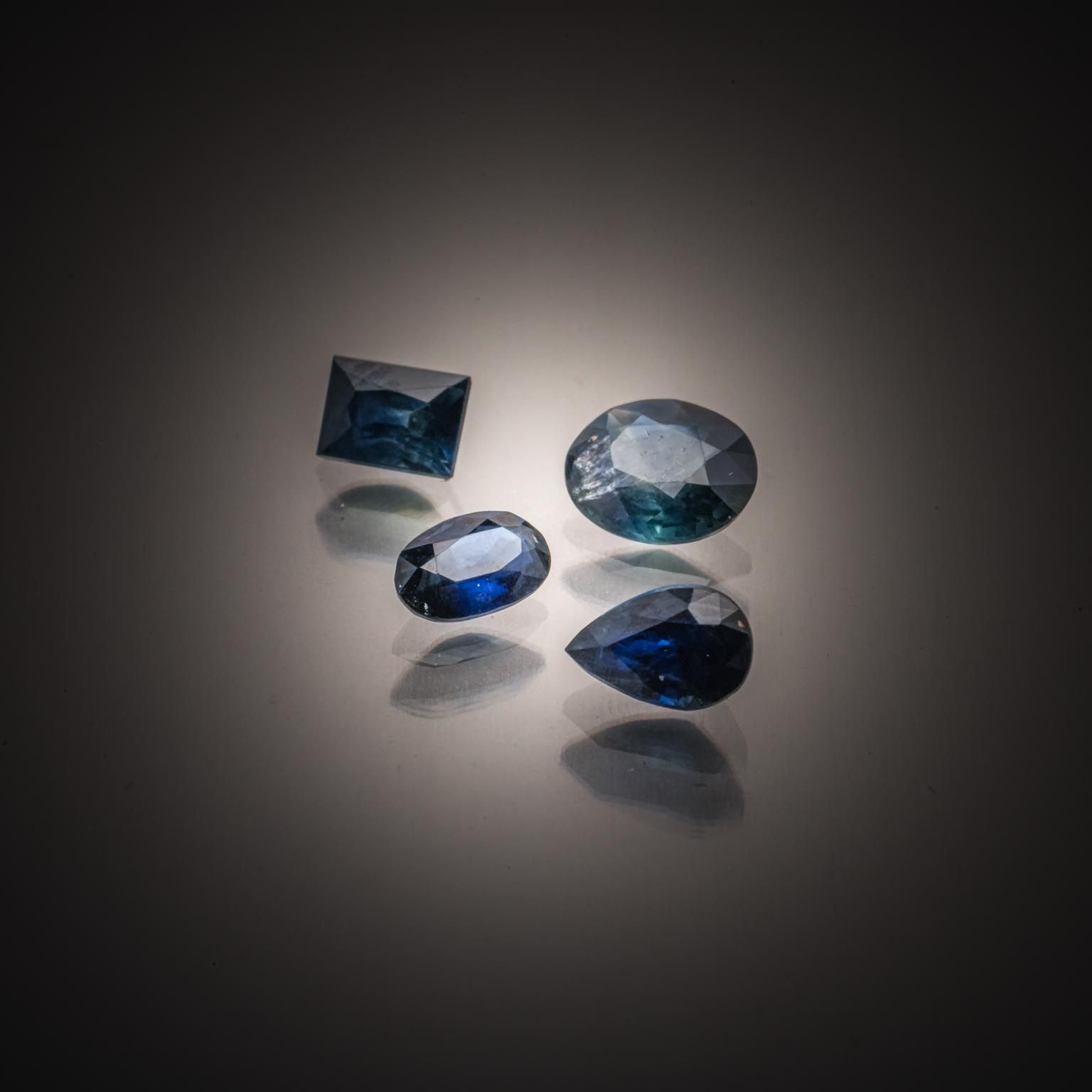 Lot de quatre saphirs bleus/verts sur papier. - Lazuli