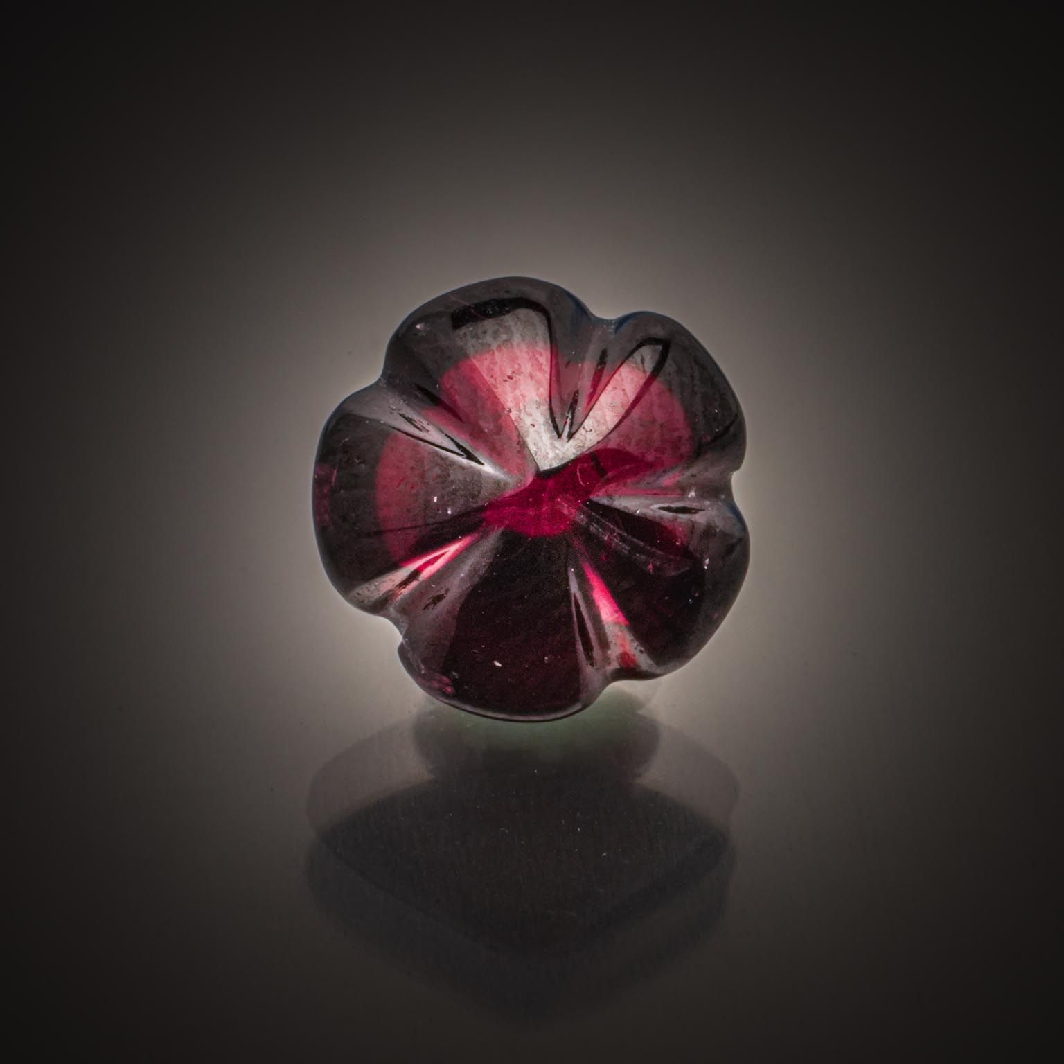 Grenat rhodolite rouge ovale sur papier. - Lazuli