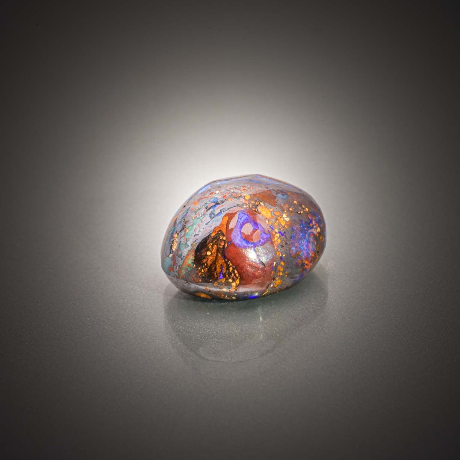 Opale boulder ovale cabochon sur papier. - Lazuli