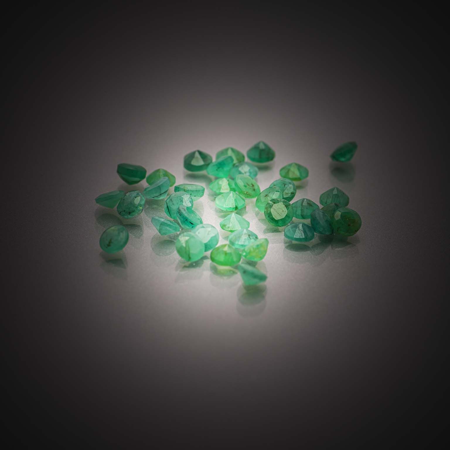 Lot d&rsquo;émeraudes rondes sur papier. - Lazuli