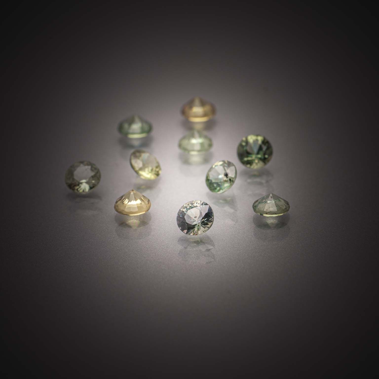 Lot de saphirs verts ronds sur papier. - Lazuli