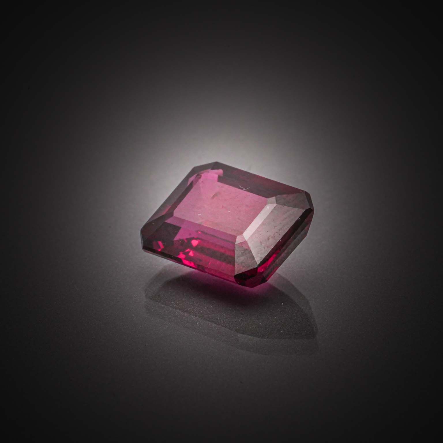 Grenat rhodolite rectangulaire à pans coupés sur papier. - Lazuli