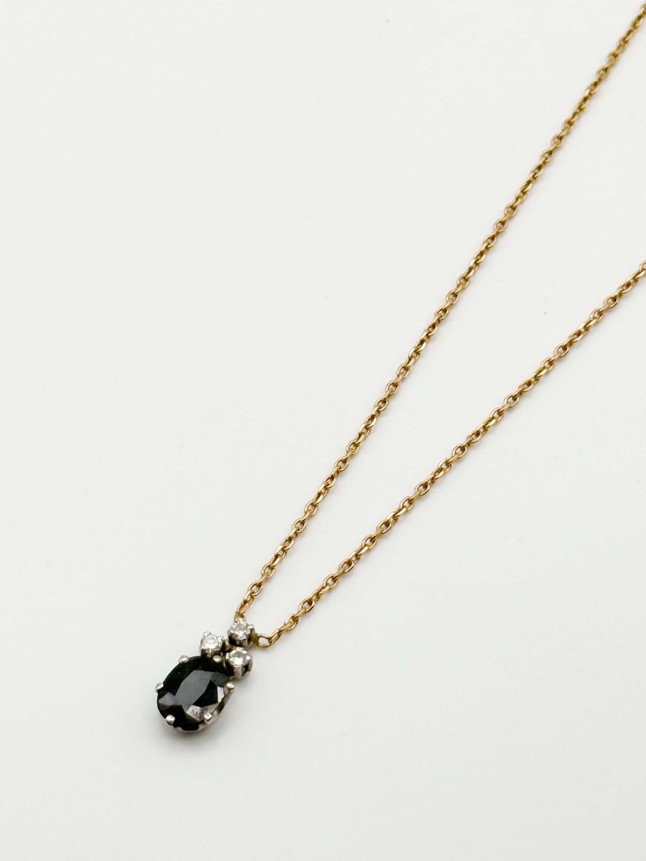 Collier en or jaune et gris (750 millièmes) formé d&rsquo;un chaîne à maille forçat et d&rsquo;un pendentif orné d&rsquo;un saphir ovale et de trois diamants ronds. - Lazuli