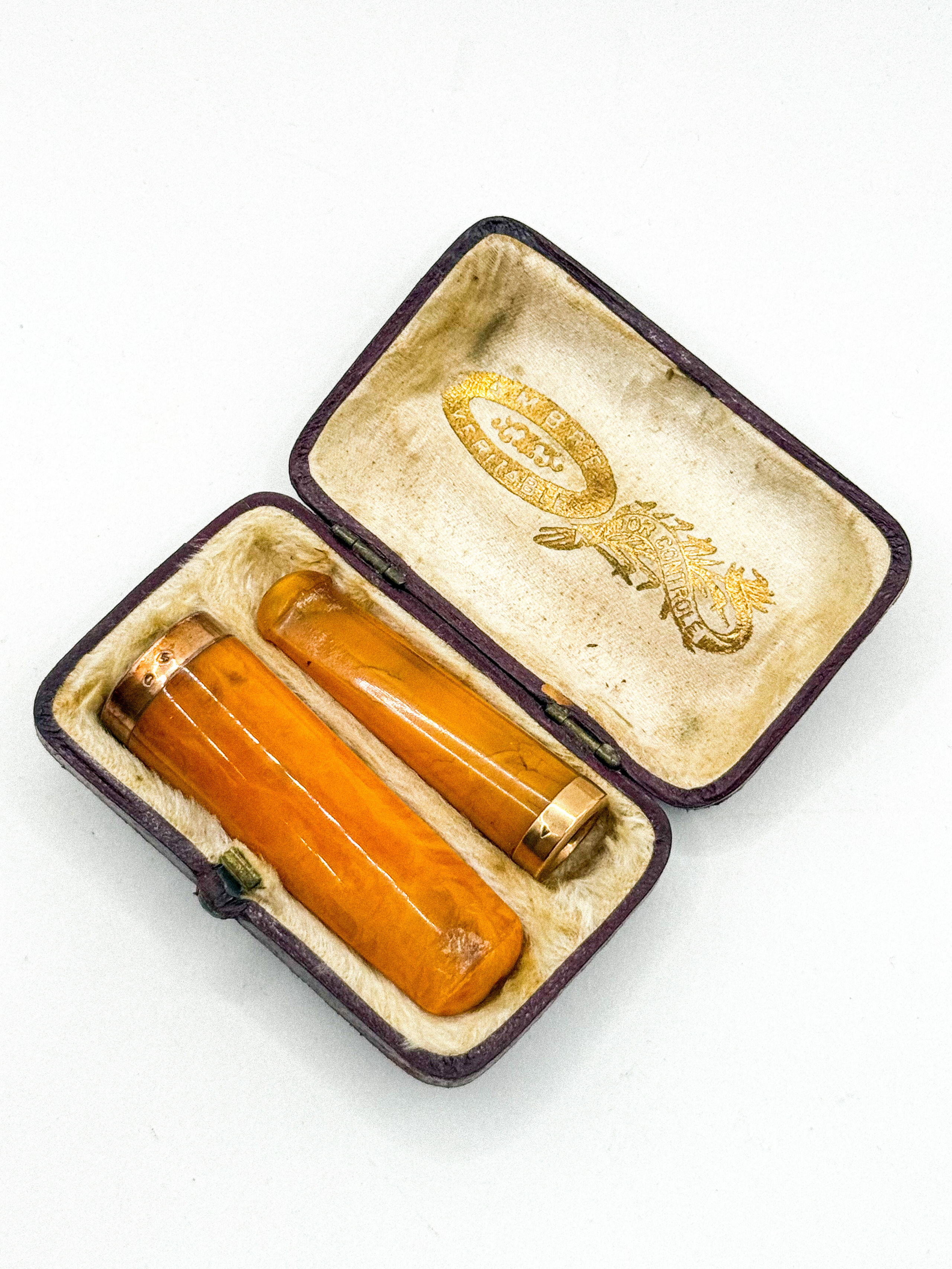 Lot de deux fume-cigarettes en or jaune (750 millièmes) et bakélite à l&rsquo;imitation de l&rsquo;ambre. - Lazuli