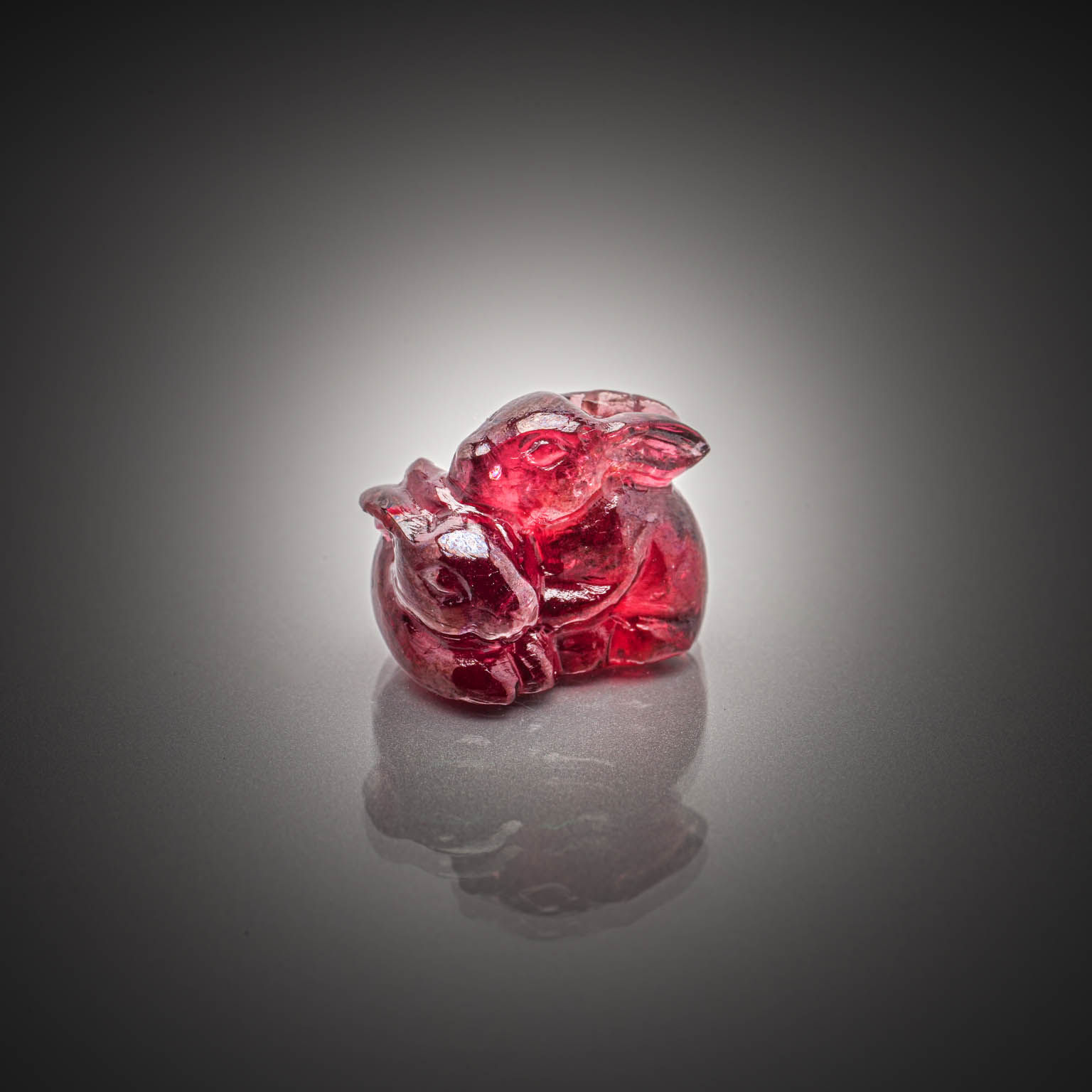 Grenat rhodolite rose stulisant un lapin sur papier. - Lazuli
