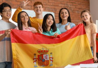 Group of Spanish language students holding a Spanish flag