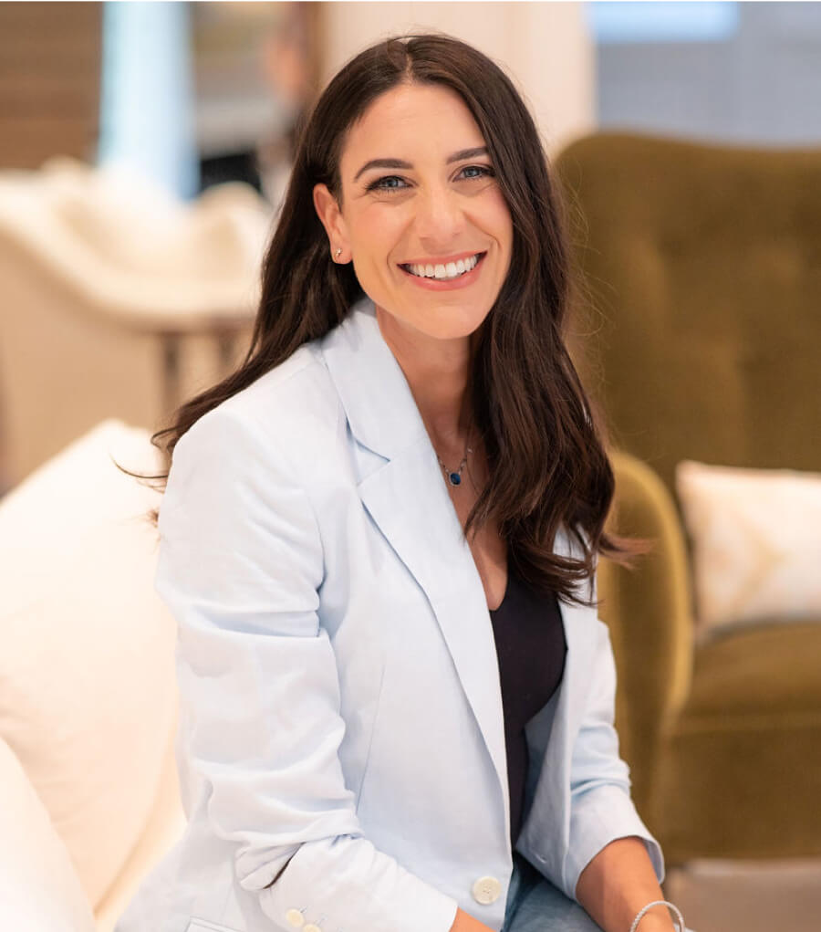 Picture of Jennifer Friedman smiling at the camera while holding a baby.