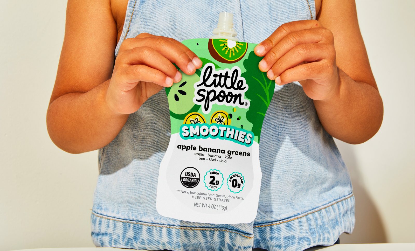 Child holding a Little Spoon Smoothies pouch