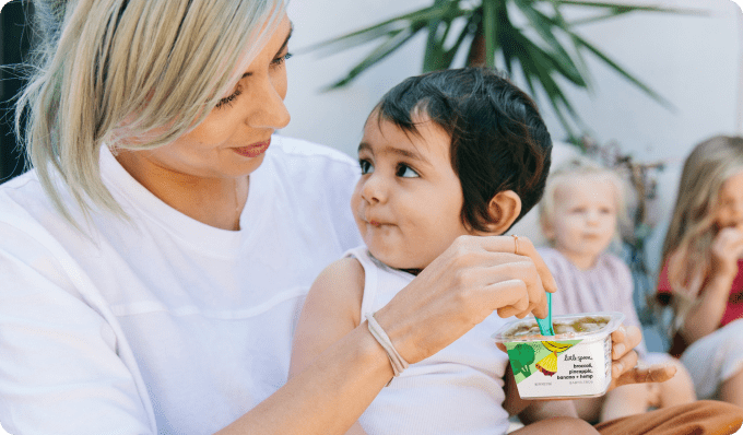 Mom feeding a child with little spoon blends