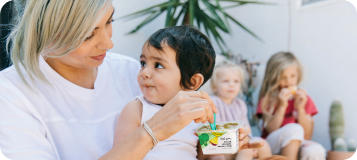 Mom feeding a child with little spoon blends