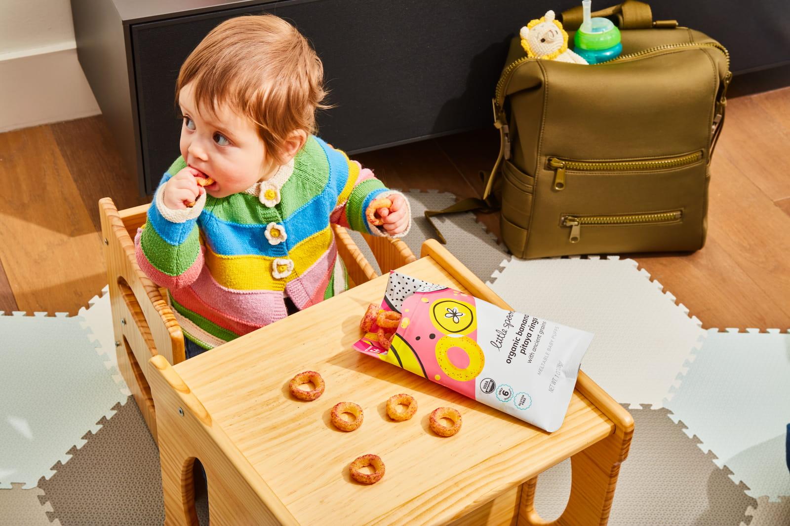 Photo of a kid eating little spoon puffs