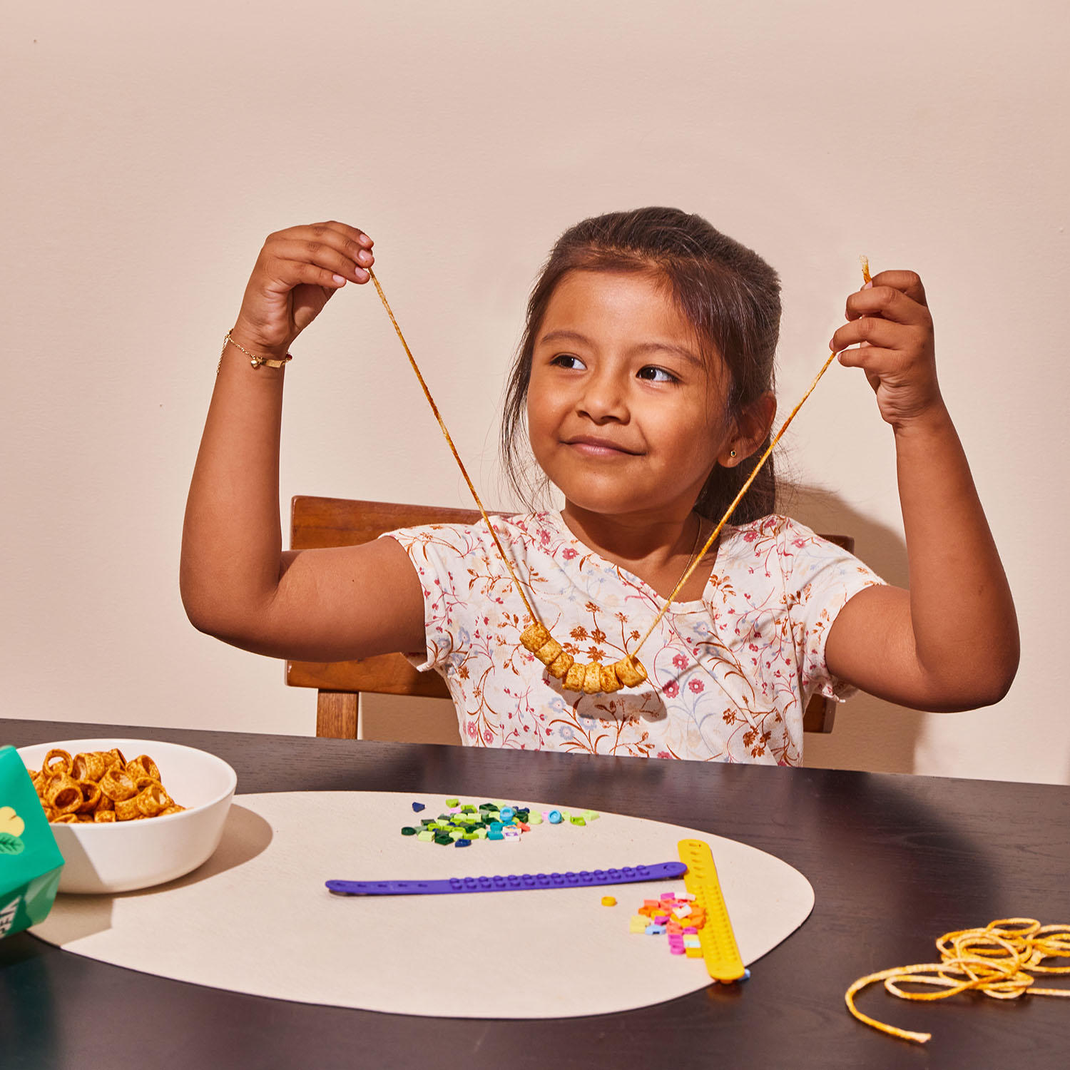 Girl making a necklace of Pizzalicious Veggie Loops Snack