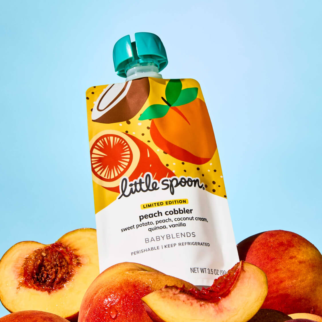 Limited Edition Peach Cobbler Babyblend pouch on top of fresh whole and sliced peaches