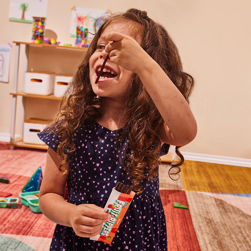 Girl eating Fruit Ripper Snacks for Toddler