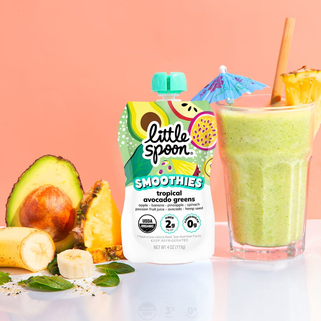 Tropical Avocado Greens Little Spoon smoothie next to tropical greens smoothie in a glass with ingredients from the smoothie