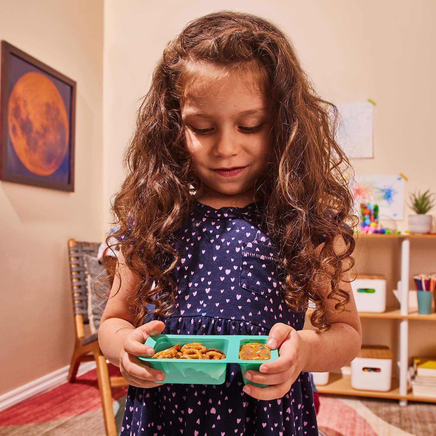 Girl holding Confetti Cake Dip + Pretzels Toddler Snack