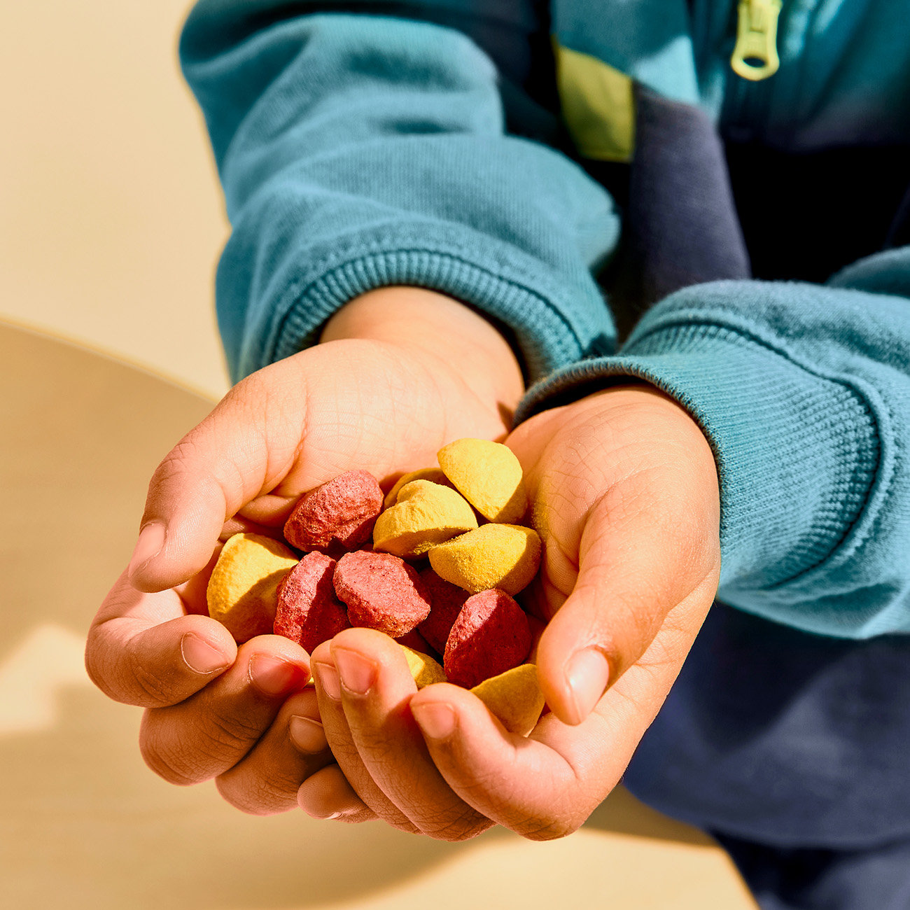 child's hand holding a mix of coconut smoothie melts