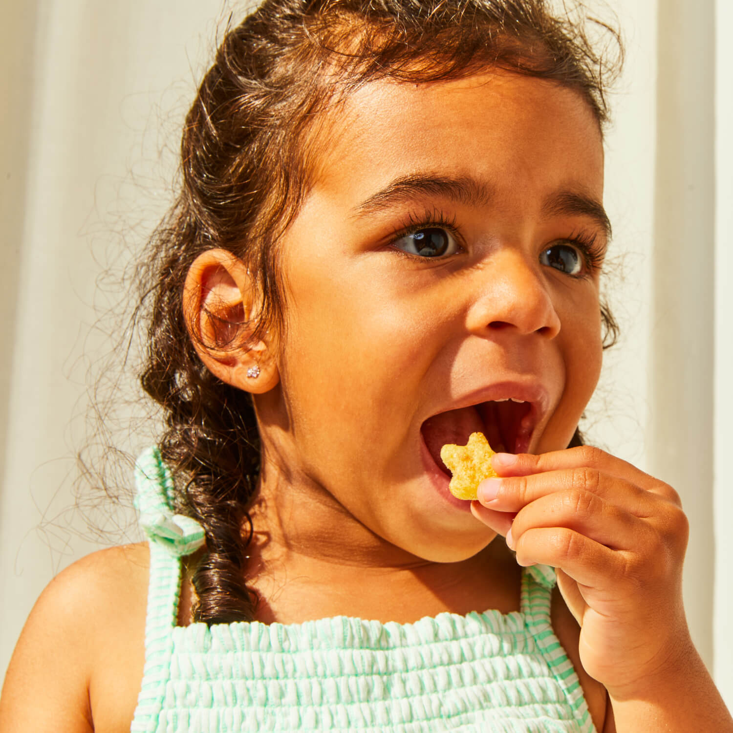 Image of toddler eating a White Cheddar Stellar Puff.