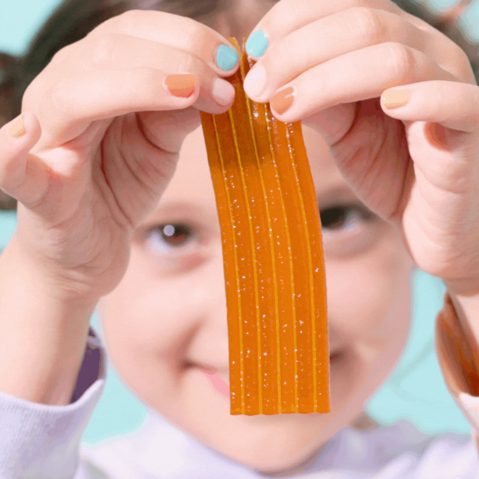 Girl ripping Mango Toddler Snack