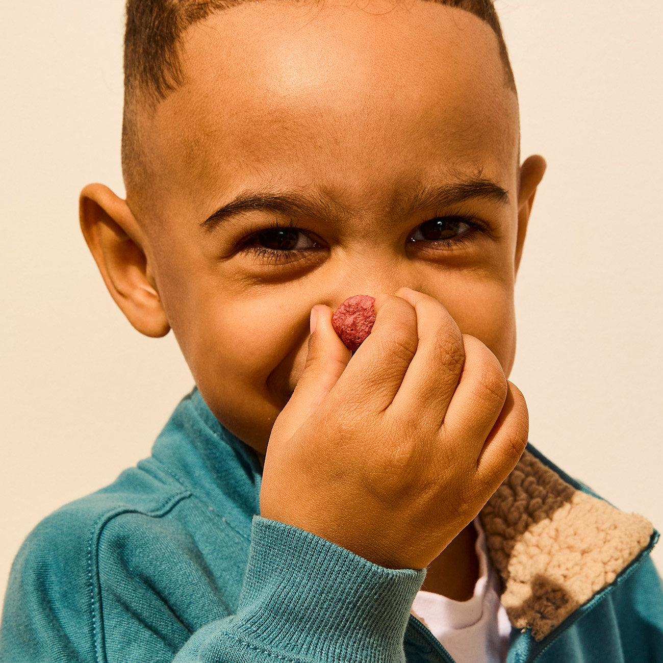 child holding a coconut smoothie melt in front of their nose