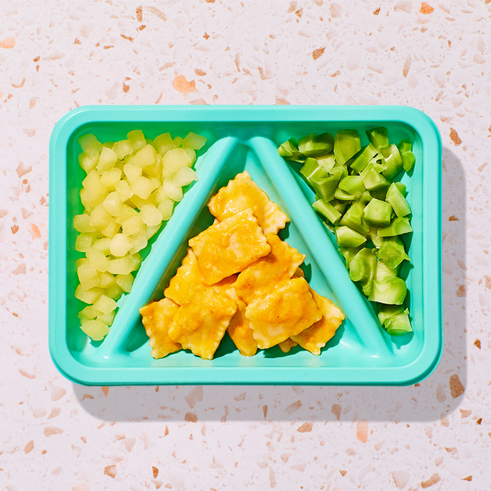 butternut squash ravioli biteable with pumpkin sauce and diced apples and broccoli