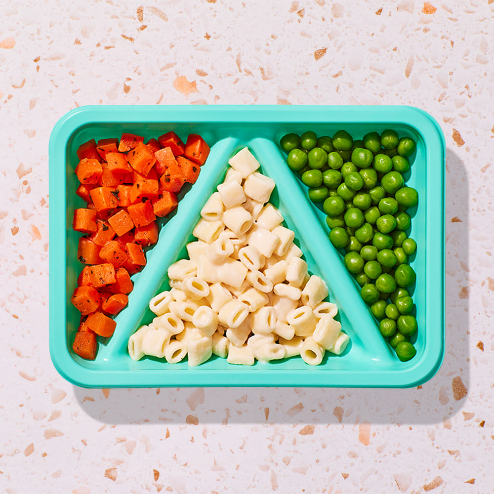 mini white mac and cheese biteable with herb tossed carrots and peas