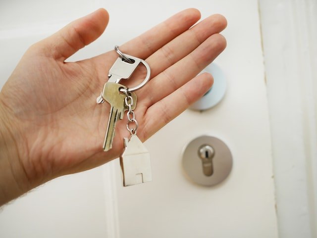 Holding keys to rental property in front of door