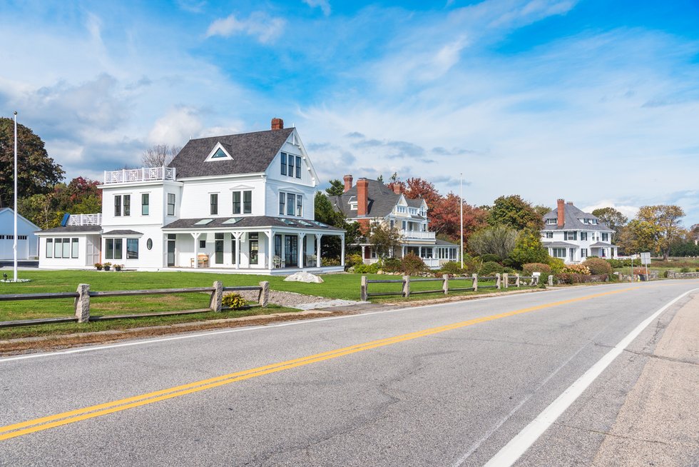 Empty stretch of a coastal road lined with beautiful detached houses on a clear autumn day
