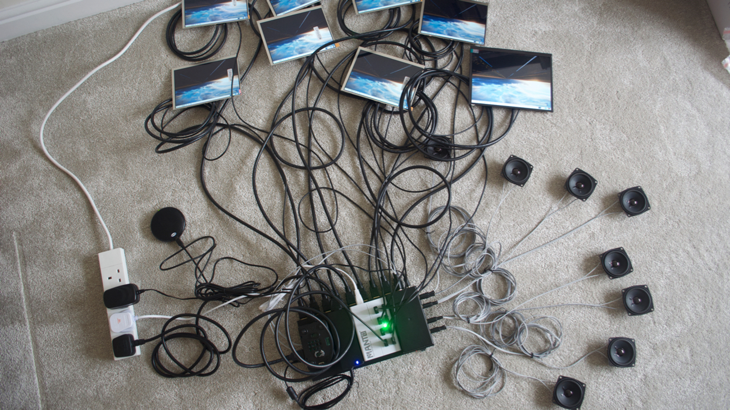 electronics and cables for 8 screens, speakers and controls arranged on a floor