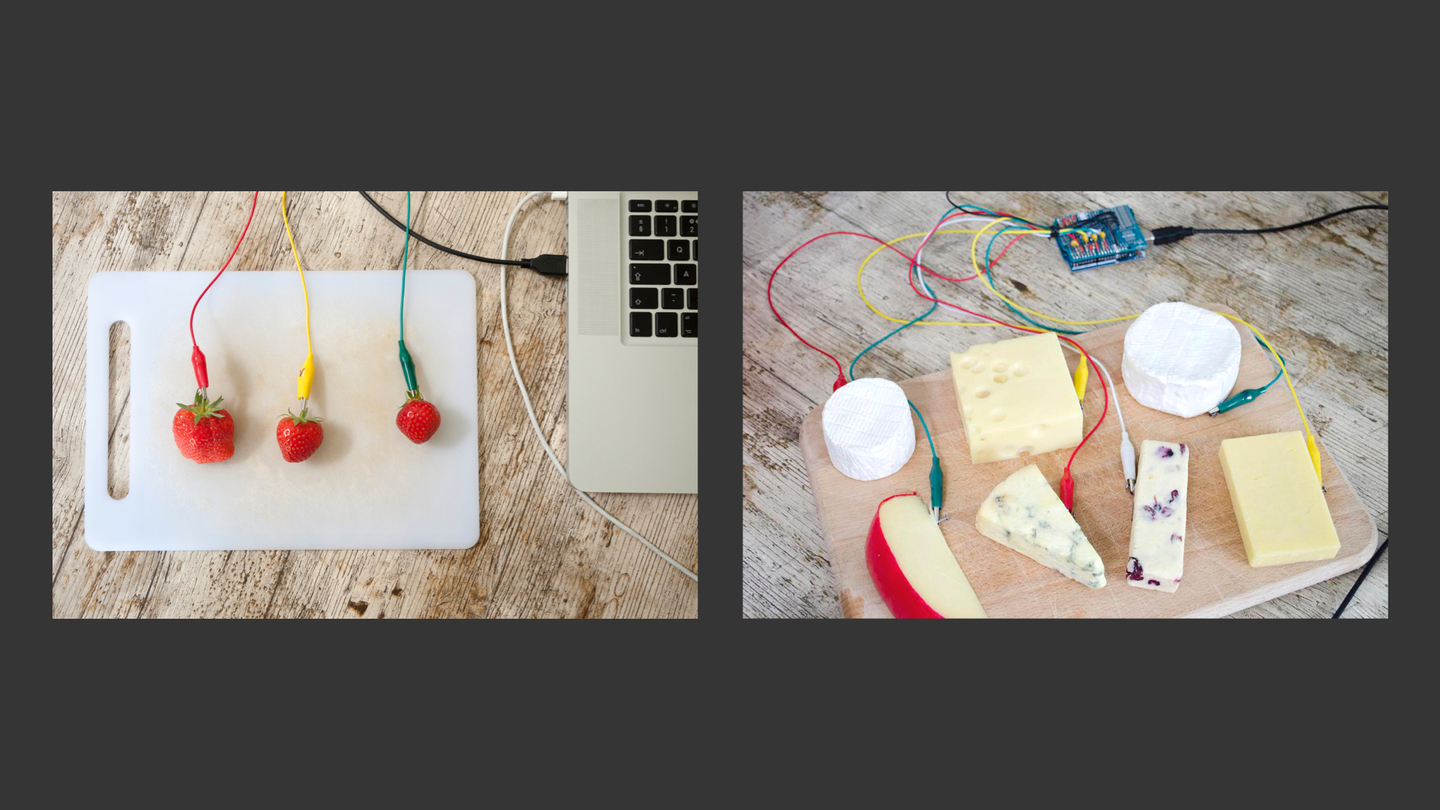 Photograph of strawberries and cheese connected to a mac laptop with colourful cables